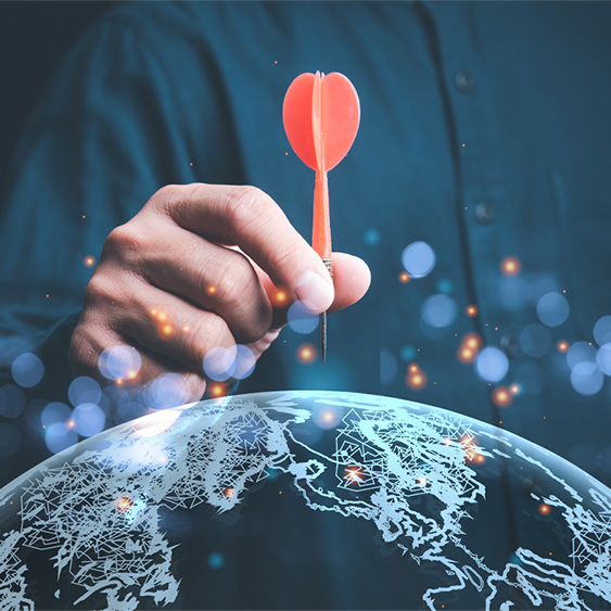 Man Holding Dart Over Dark-Colored Globe