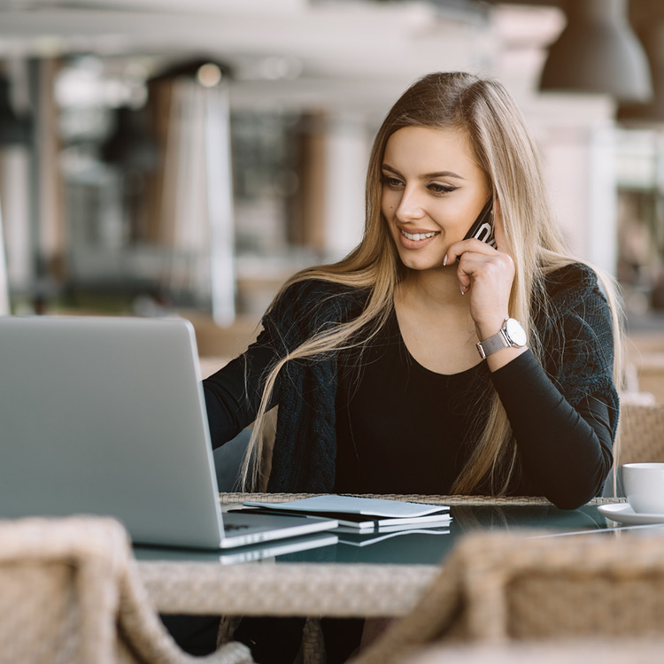 Woman Talking on the Phone While on Laptop